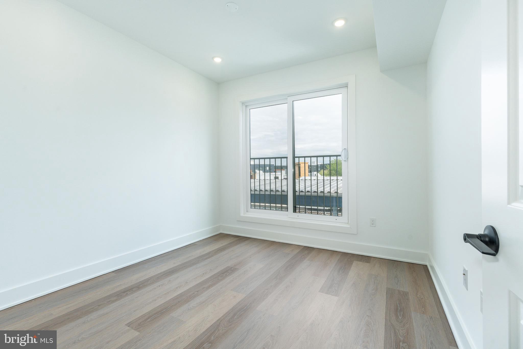 2252 North Front Street, Unit 2 Philadelphia, PA 19133 - Photo 9 of 15 an empty room with wooden floor and windows