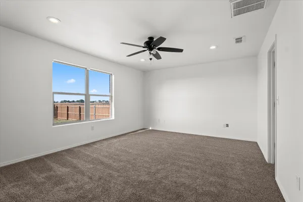 an empty room with windows and fan