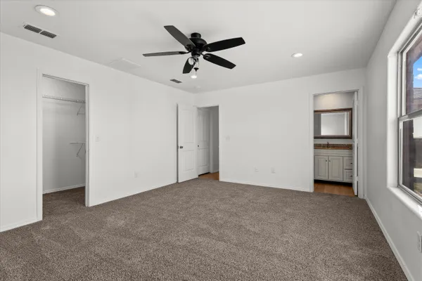 a view of a livingroom with a ceiling fan & entryway