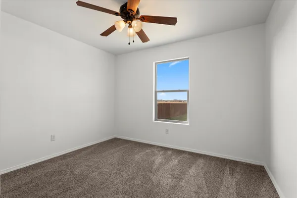 an empty room with a window and a fan