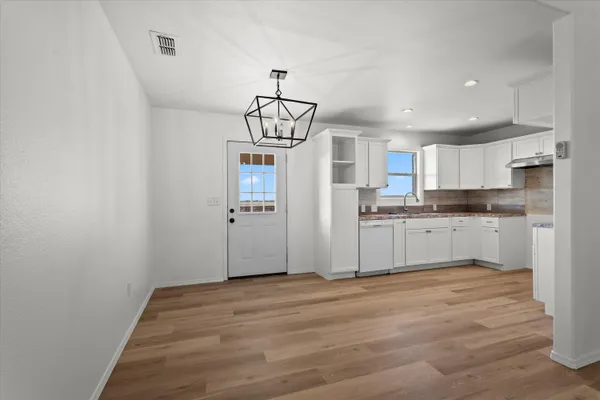 a view of a kitchen with a sink cabinets and wooden floor