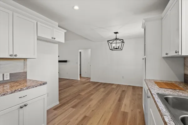 a kitchen with kitchen island white cabinets and refrigerator