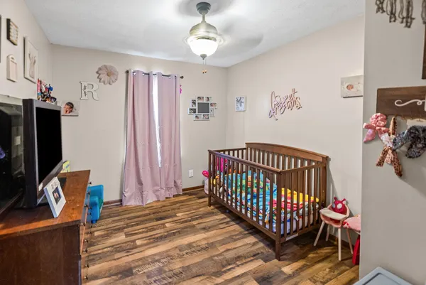 a bedroom with a bed and a flat tv screen on the dresser