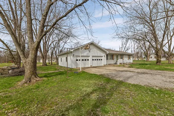 a view of a house with a big yard and large trees