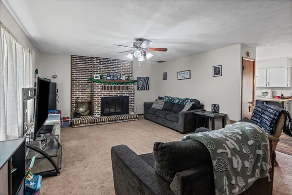 a living room with furniture a fireplace and a flat screen tv