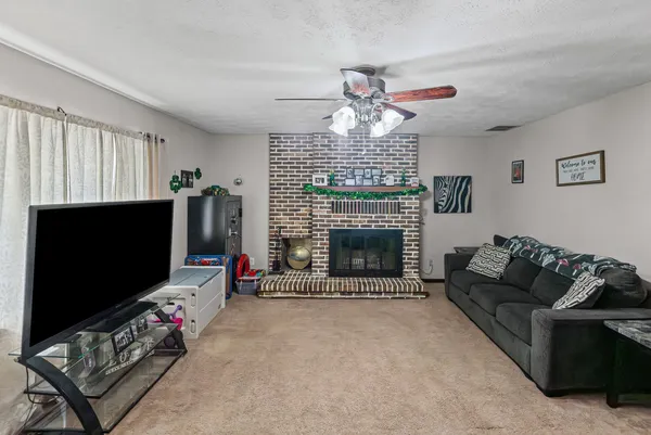 a living room with furniture a flat screen tv and a fireplace