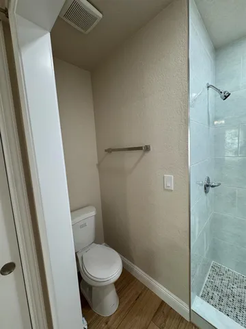 a bathroom with a toilet and a shower