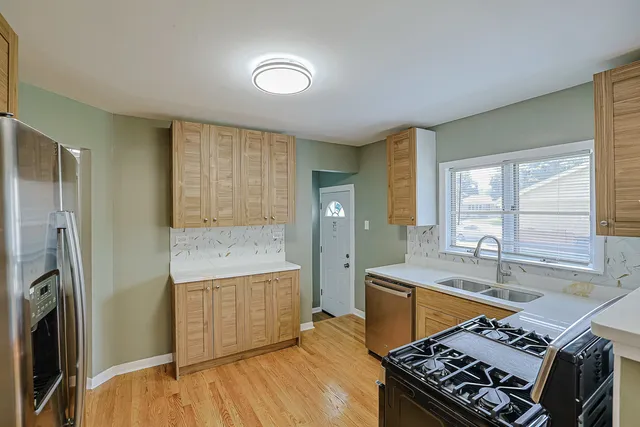 a kitchen with stainless steel appliances granite countertop a sink stove and refrigerator