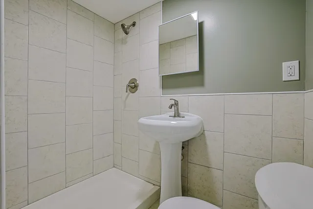 a bathroom with a sink a toilet and shower