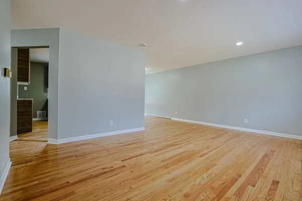 a view of an empty room with wooden floor