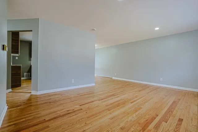 a view of an empty room with wooden floor