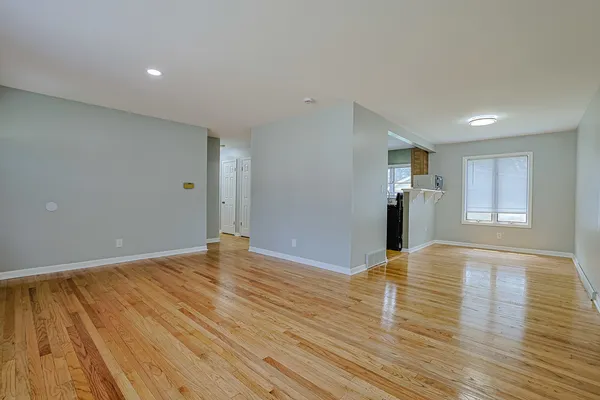 a view of empty room with wooden floor