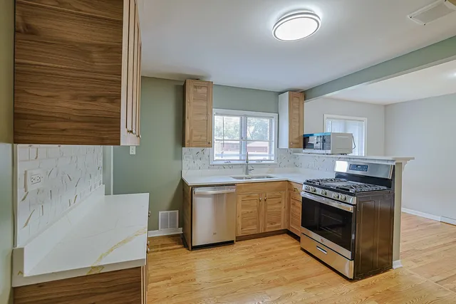 a kitchen with stainless steel appliances granite countertop a stove and a sink