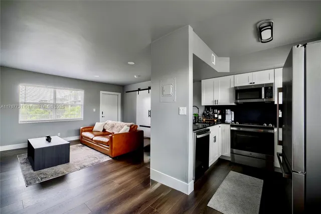 a kitchen with stainless steel appliances kitchen island granite countertop a refrigerator and a stove top oven