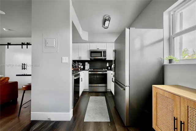 a kitchen with a refrigerator and a stove top oven