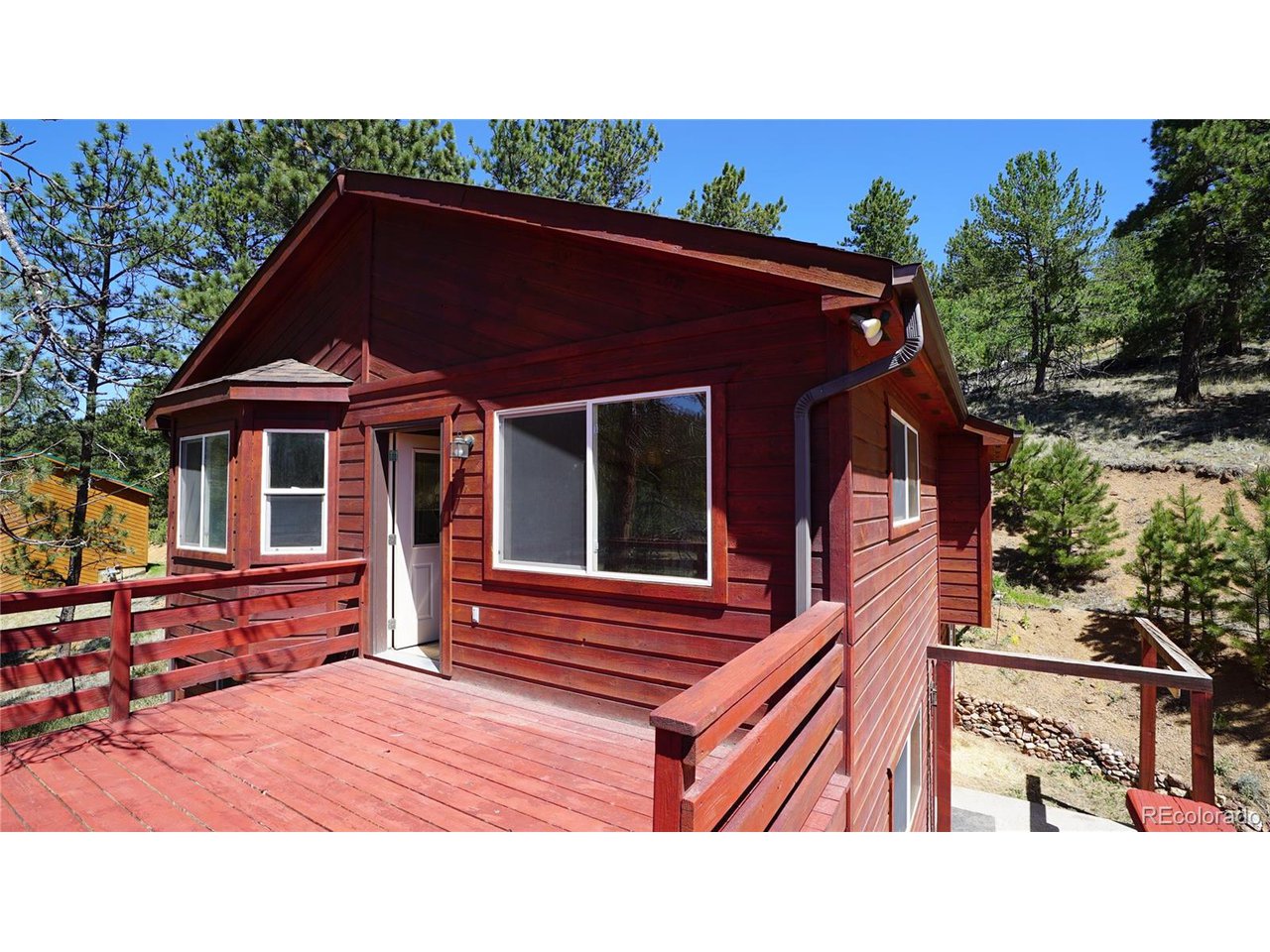 261 Wilkins Road Bailey, CO 80421 - Photo 18 of 39 a terrace of a house with wooden floor outdoor seating and barbeque oven