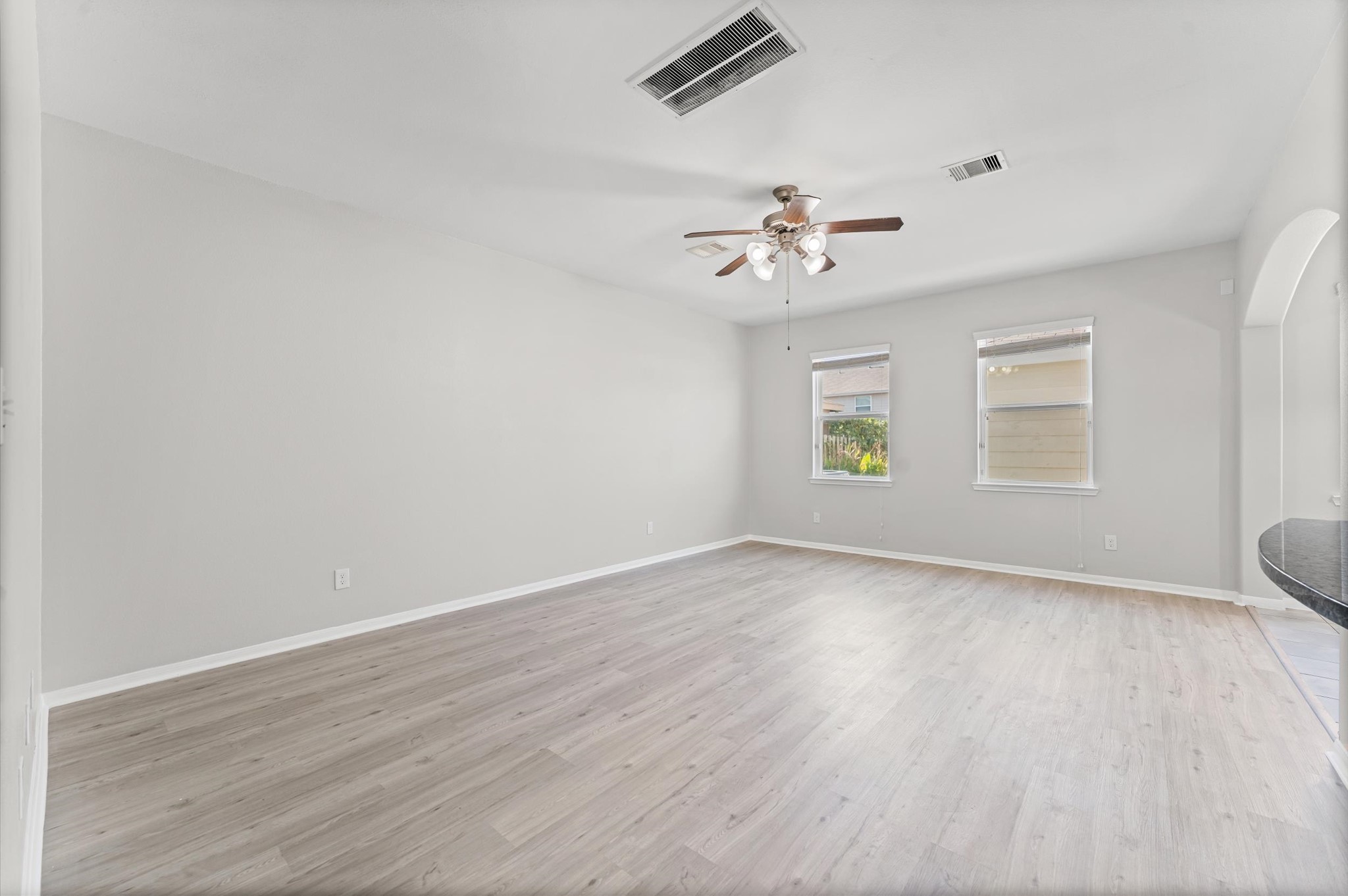 7018 Granite Terrace Lane Houston, TX 77083 - Photo 5 of 18 an empty room with wooden floor chandelier fan and windows