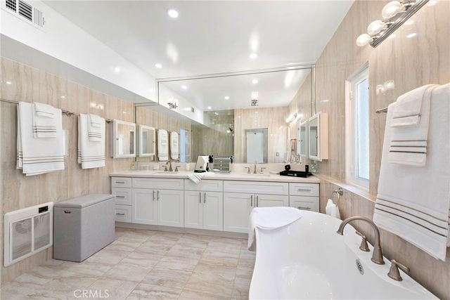 a kitchen with stainless steel appliances kitchen island granite countertop a stove a refrigerator a dining table and chairs with wooden floor