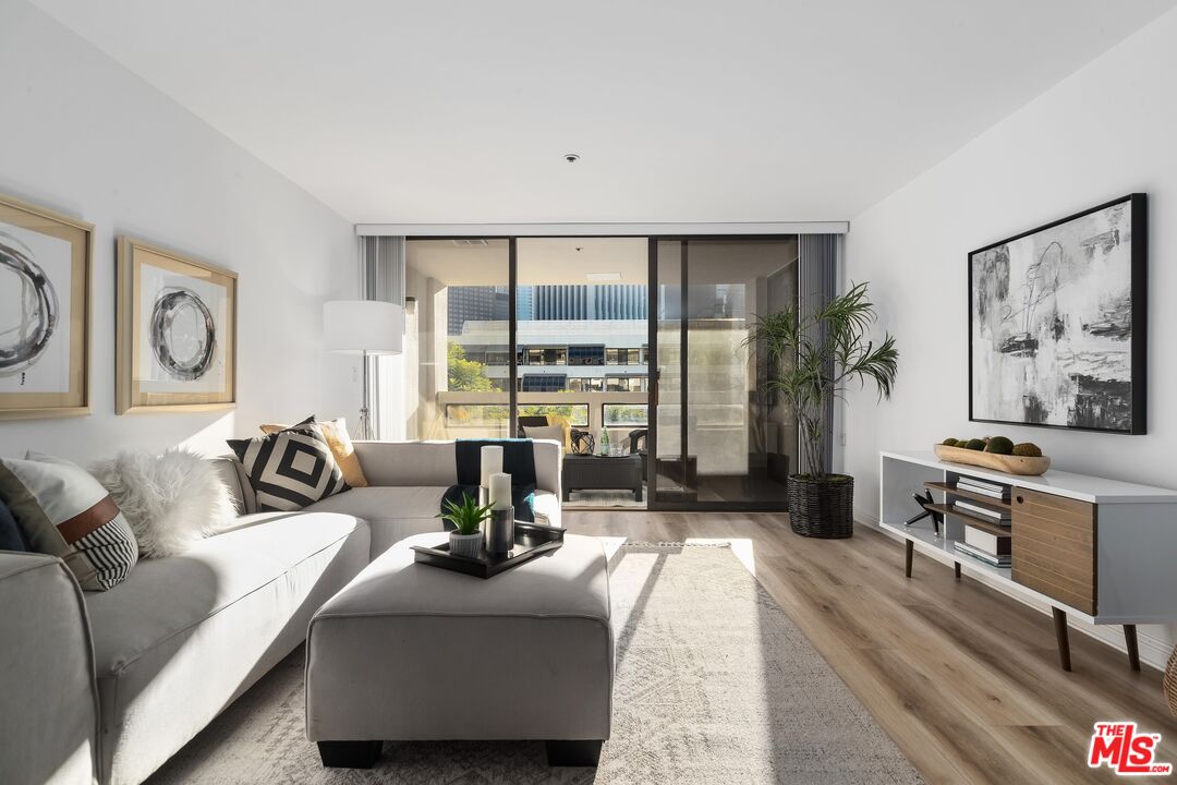 a living room with furniture large window and flat screen tv