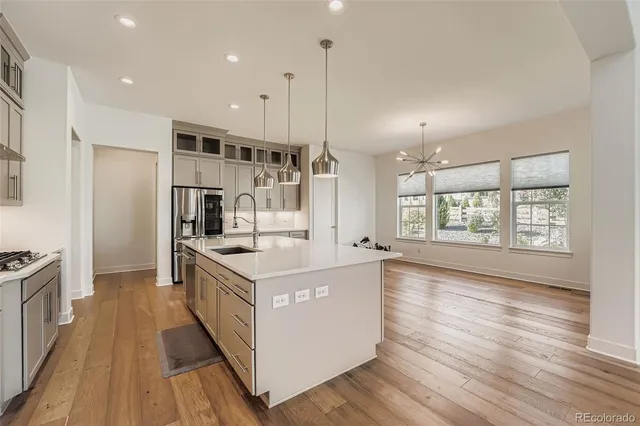 a kitchen with stainless steel appliances granite countertop a refrigerator a stove and a sink