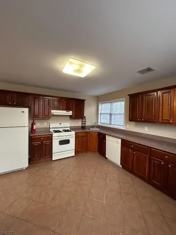 a large kitchen with stainless steel appliances granite countertop a large counter top and a stove