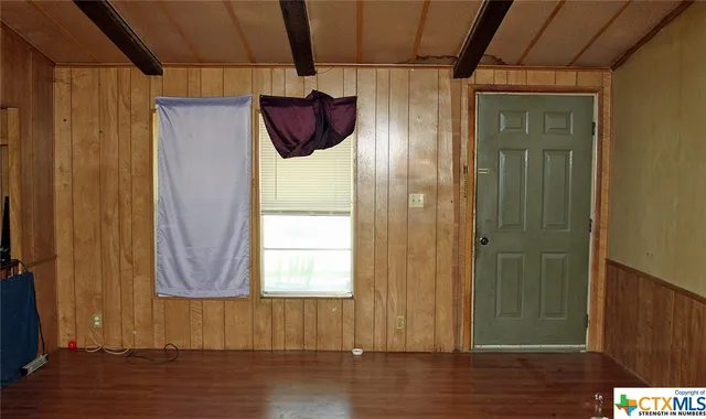 a room with wooden furniture and windows