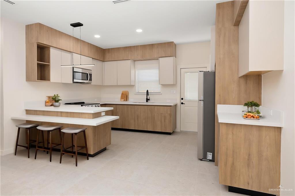 11501 North 25th Street, Unit 2 McAllen, TX 78504 - Photo 6 of 22 a kitchen with stainless steel appliances a sink a stove a refrigerator and cabinets