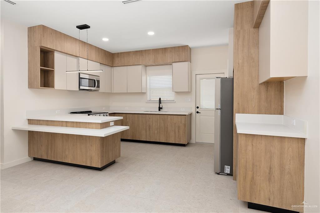 11501 North 25th Street, Unit 2 McAllen, TX 78504 - Photo 7 of 22 a kitchen with stainless steel appliances a sink a refrigerator and a stove