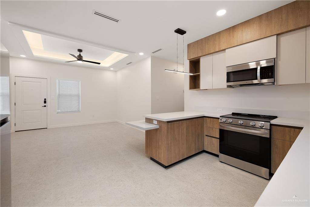 11501 North 25th Street, Unit 2 McAllen, TX 78504 - Photo 8 of 22 a kitchen with stainless steel appliances granite countertop a refrigerator a stove top oven a sink and dishwasher