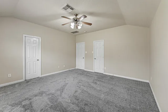 a view of an empty room with a chandelier fan