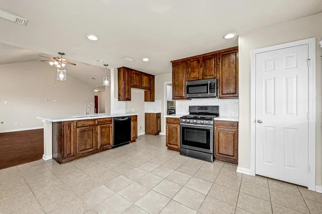 a kitchen with stainless steel appliances a stove top oven and sink