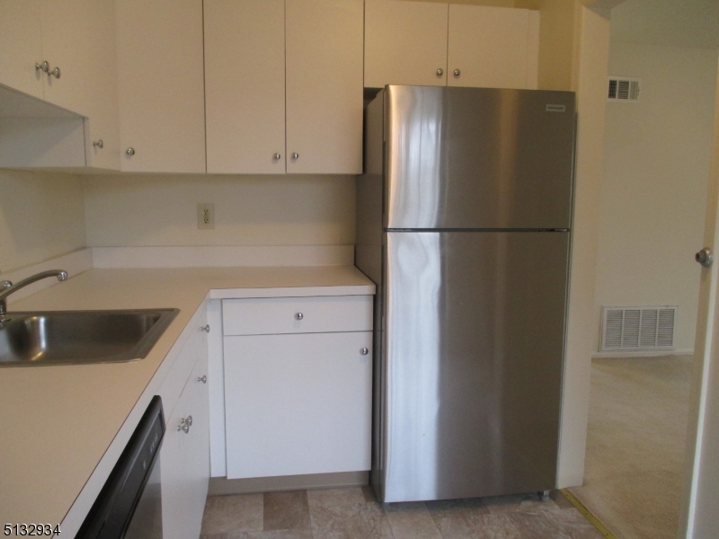 181 Long Hill Road, Unit 8 Little Falls, NJ 07424 - Photo 9 of 15 a kitchen with a refrigerator sink and cabinets
