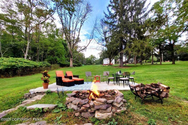 a view of a house with backyard and sitting area