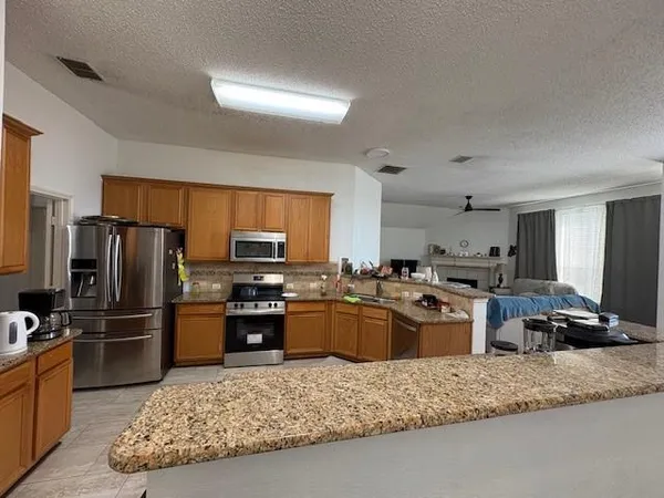 a kitchen with granite countertop stainless steel appliances and a counter space