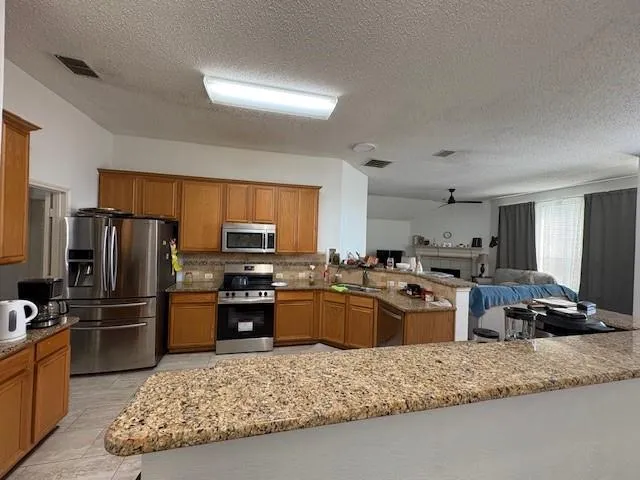 a kitchen with granite countertop stainless steel appliances and a counter space