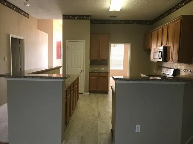 a kitchen with granite countertop a refrigerator and a stove