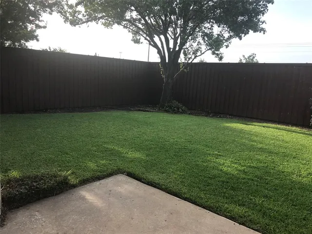 a view of a backyard with wooden fence