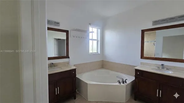 a bathroom with a tub sink and mirror