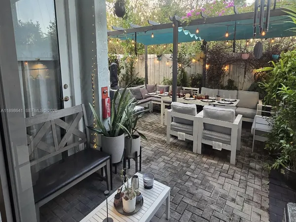 a view of a patio with a dining table and chairs potted plants