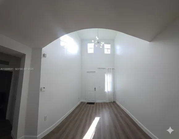 en empty room with wooden floor and window