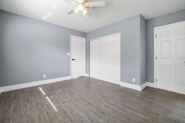 a view of an empty room with wooden floor