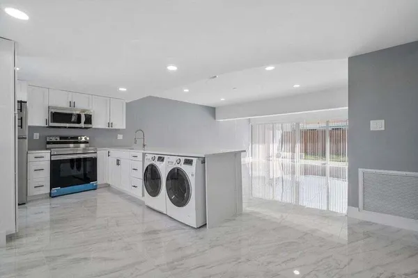 a kitchen with stainless steel appliances granite countertop a refrigerator and a stove top oven