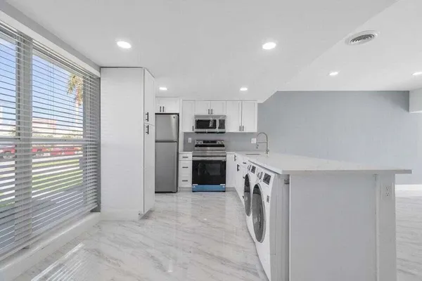 a kitchen with a sink stainless steel appliances and cabinets