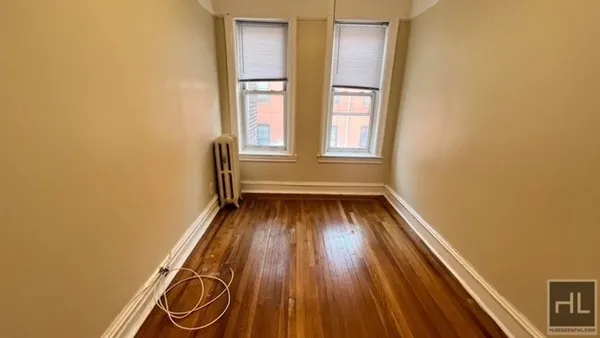 a view of a room with wooden floor and windows