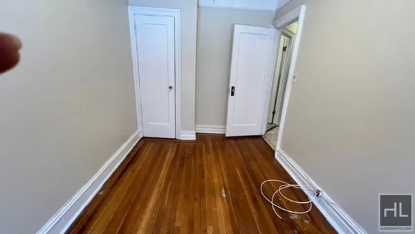 a view of a room with wooden floor and white walls