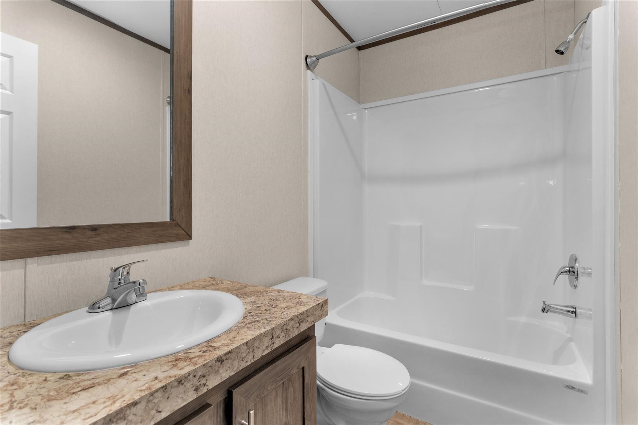 10161 Pollard Road, Unit 1 Willis, TX 77318 - Photo 16 of 22 a bathroom with a granite countertop sink a toilet and shower