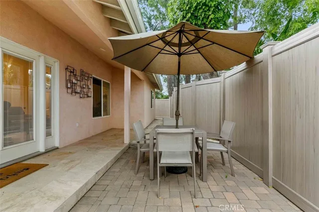 a patio with a table and chairs under an umbrella