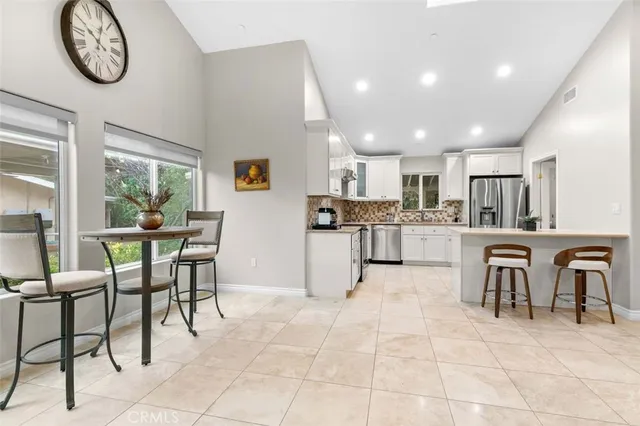 a kitchen with a dining table chairs and cabinets