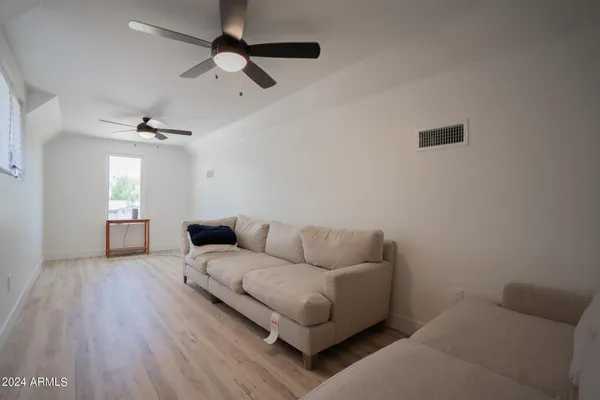 a living room with furniture and a ceiling fan