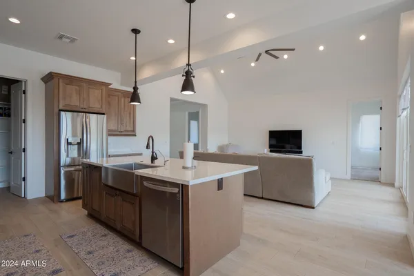 a kitchen with a sink a counter top space and stainless steel appliances